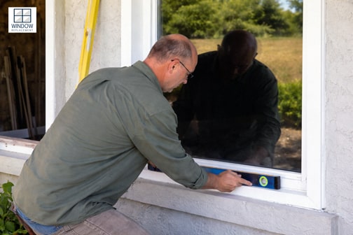 Window replacement technician leveling a new window at a Rossmoor residence